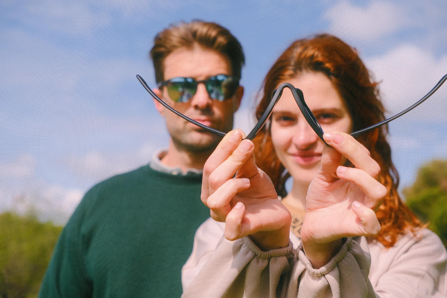 Una pareja retuerce unas gafas flexibles delante de la cara