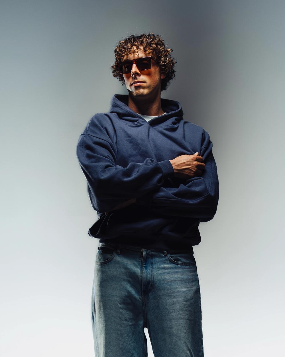 Modelo con sudadera azul marino y gafas de sol