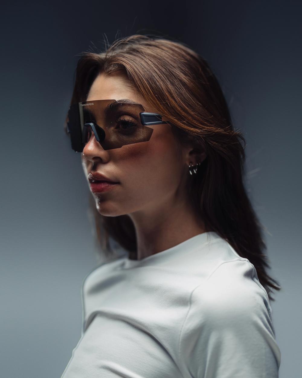 Retrato de una modelo con gafas de sol envolventes sobre fondo gris